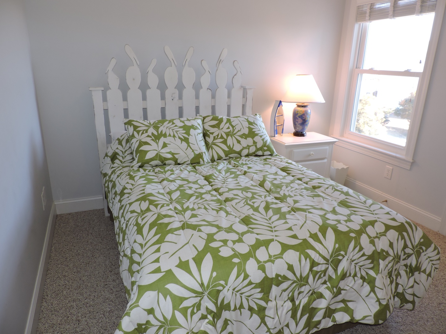 Drift off in this cozy bedroom with its charming picket fence headboard and bright tropical bedding that brings island vibes indoors.