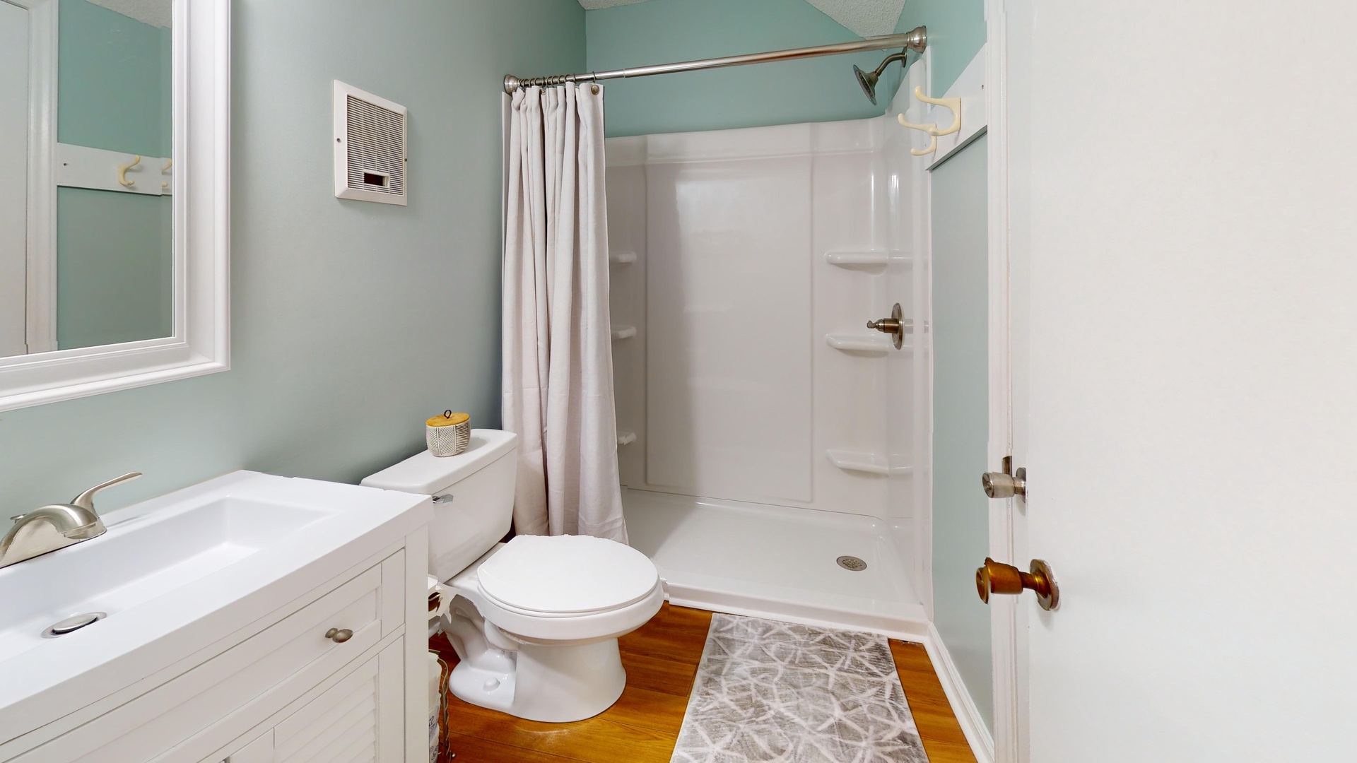 Refresh in your private bathroom with soothing mint walls, clean white fixtures, and a spacious walk-in shower perfect for unwinding after your adventures.