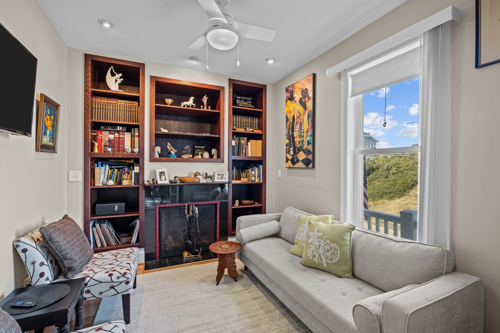 Curl up with your favorite book in this inviting living space, where built-in shelves and a cozy fireplace create the perfect reading retreat.