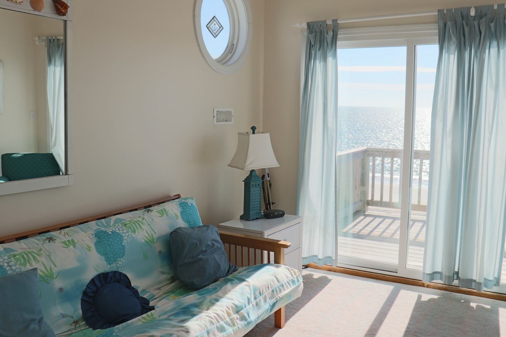 Relax in your bright coastal living room with ocean-inspired decor and direct balcony access to stunning sea views.
