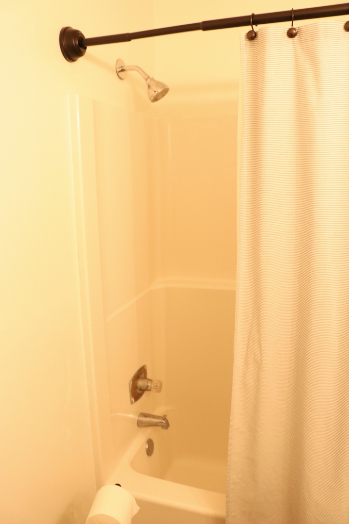 Step into your private shower-tub combo, featuring modern fixtures and a warm, welcoming atmosphere for your daily refresh.