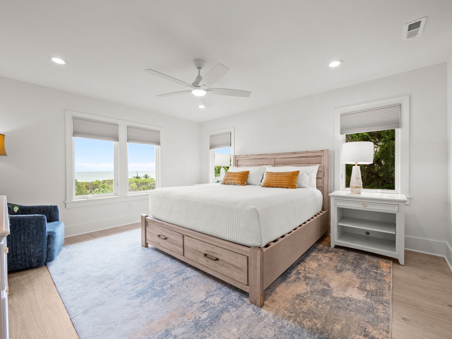 Unwind in your serene bedroom with crisp linens, natural light streaming through multiple windows, and a cozy reading nook perfect for lazy mornings.