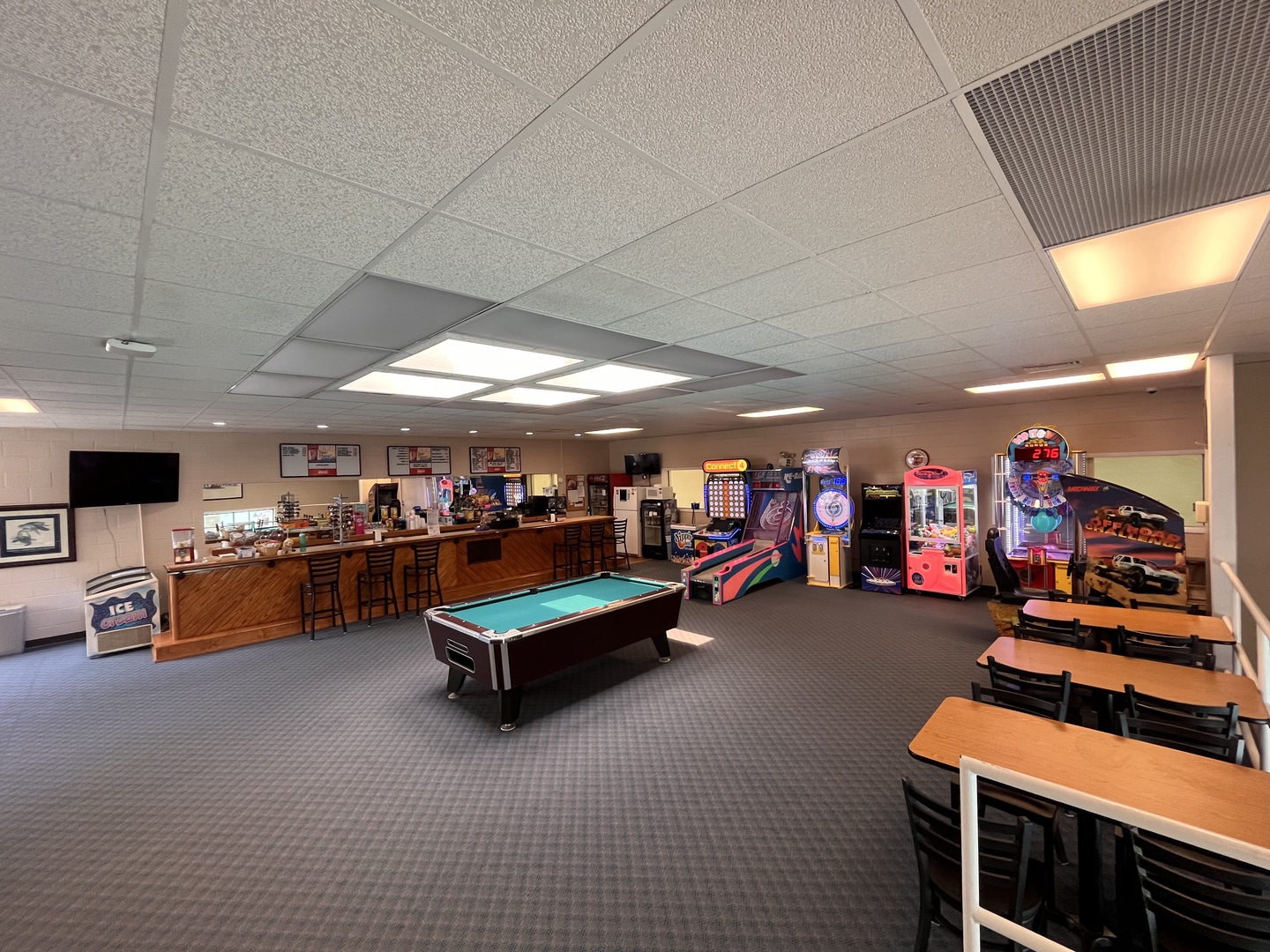 Your entertainment awaits in this spacious game room featuring pool tables, arcade games, and comfortable seating for hours of fun.