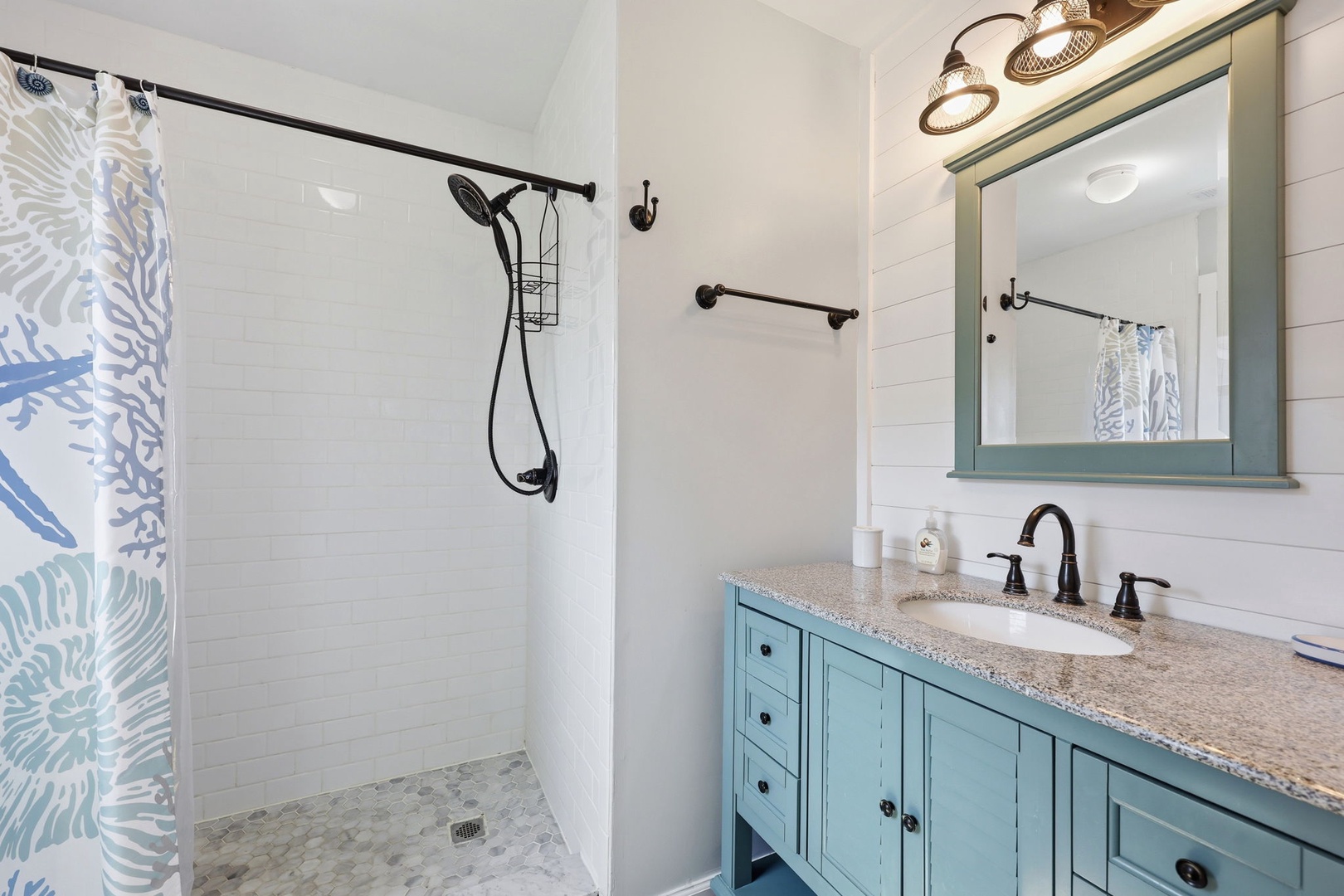 Step into your private bathroom with coastal charm—turquoise vanity, granite countertops, and a refreshing shower await your daily routine.