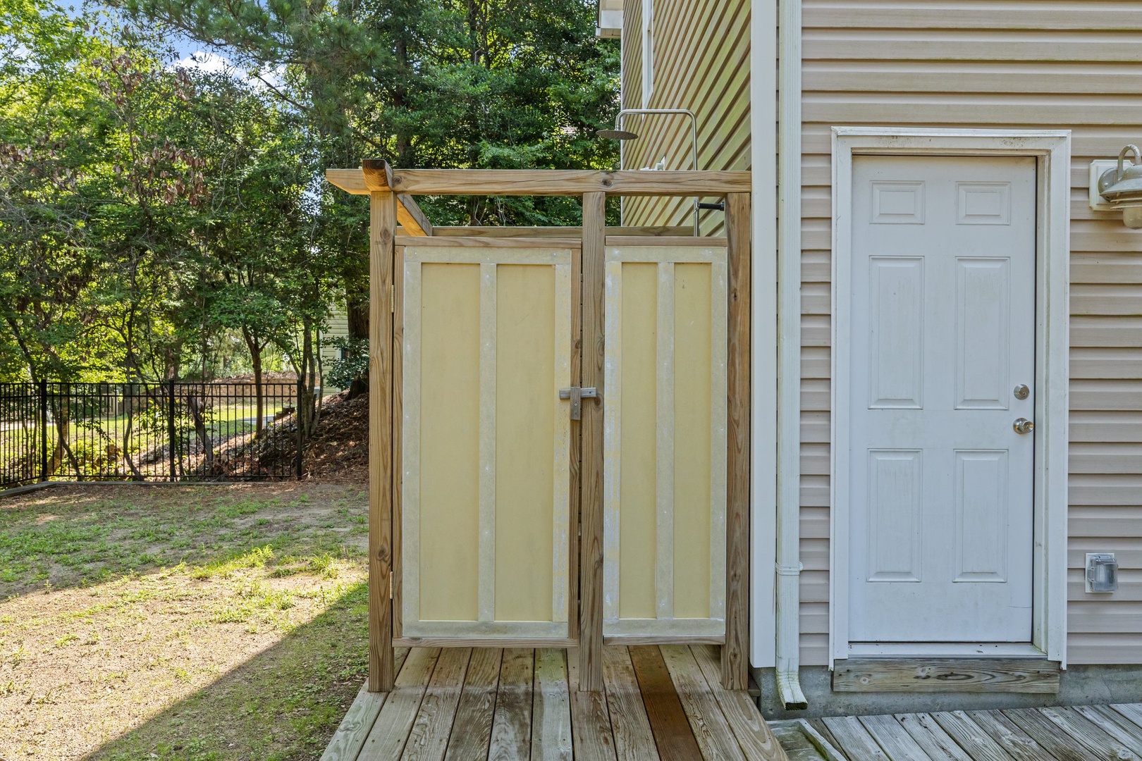 Private outdoor shower with natural wood construction offers refreshing convenience steps from your door.