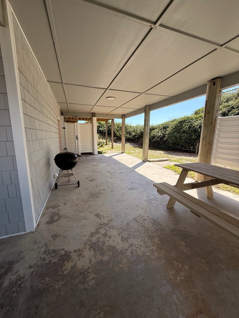 Step out to your covered patio, where a grill and picnic table set the scene for effortless outdoor meals. Sunshine and greenery surround this relaxed, private space—perfect for morning coffee or evening barbecues.
