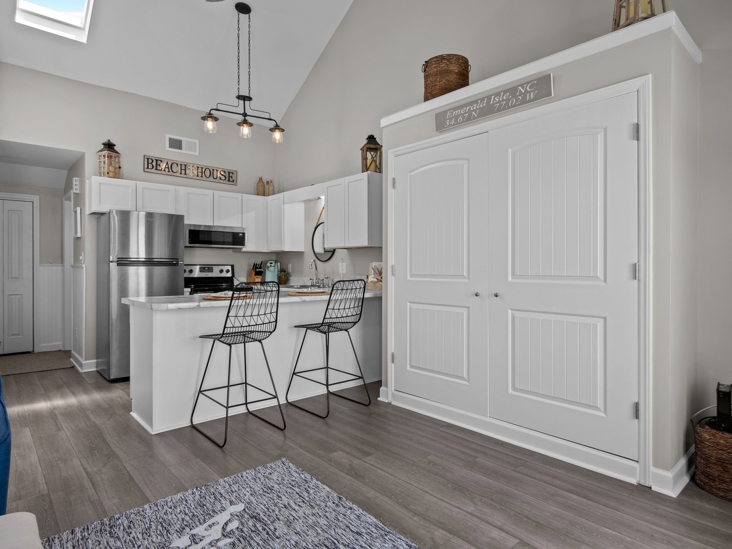 Your bright beach house kitchen awaits with modern appliances, stylish breakfast bar seating, and charming coastal décor creating the perfect space for vacation cooking.