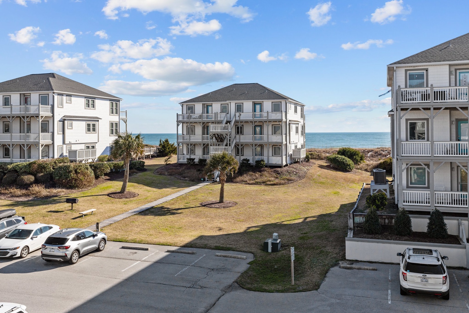 Coastal vacation rental community featuring multi-story beach homes with ocean access and convenient parking.