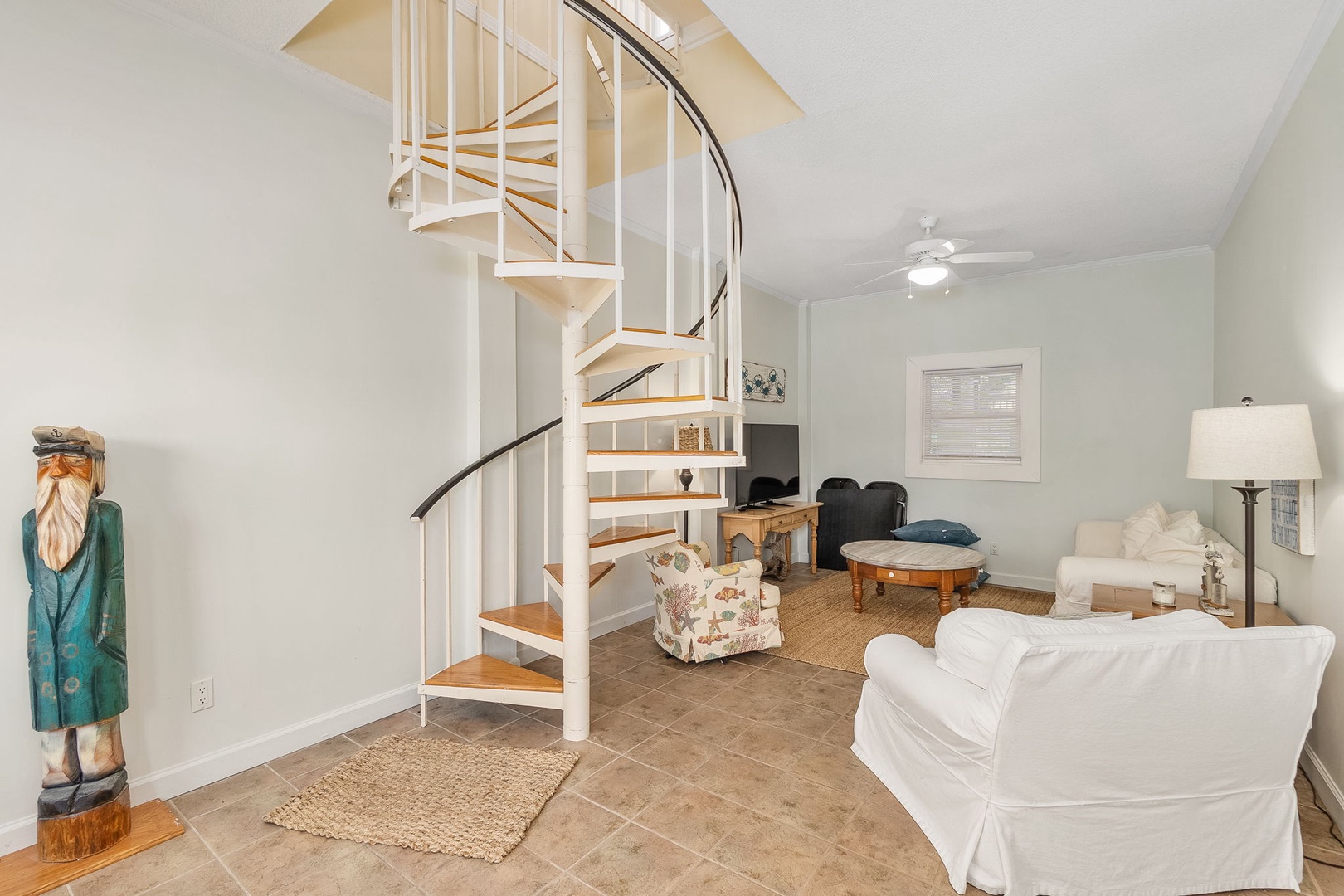 Unwind in your bright living space featuring a striking spiral staircase and comfortable seating perfect for relaxing after your adventures.