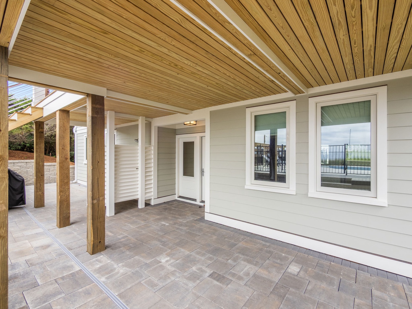 Modern entrance featuring warm wood ceiling and stone flooring leading to your private waterfront retreat.