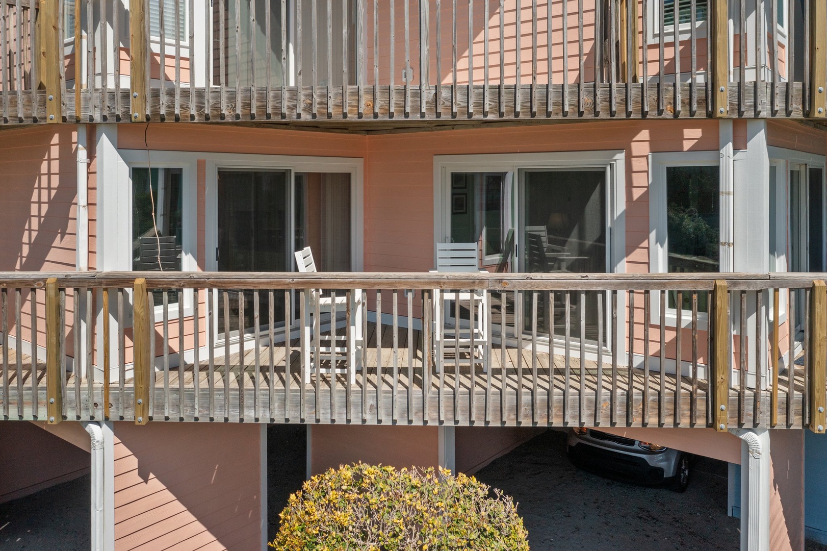 Multi-level property building with private balconies and outdoor access for each unit.