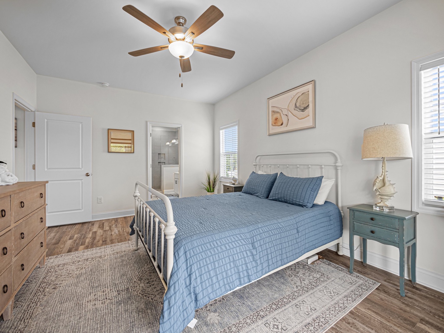Drift off to peaceful sleep in your serene bedroom, complete with ceiling fan and coastal charm.