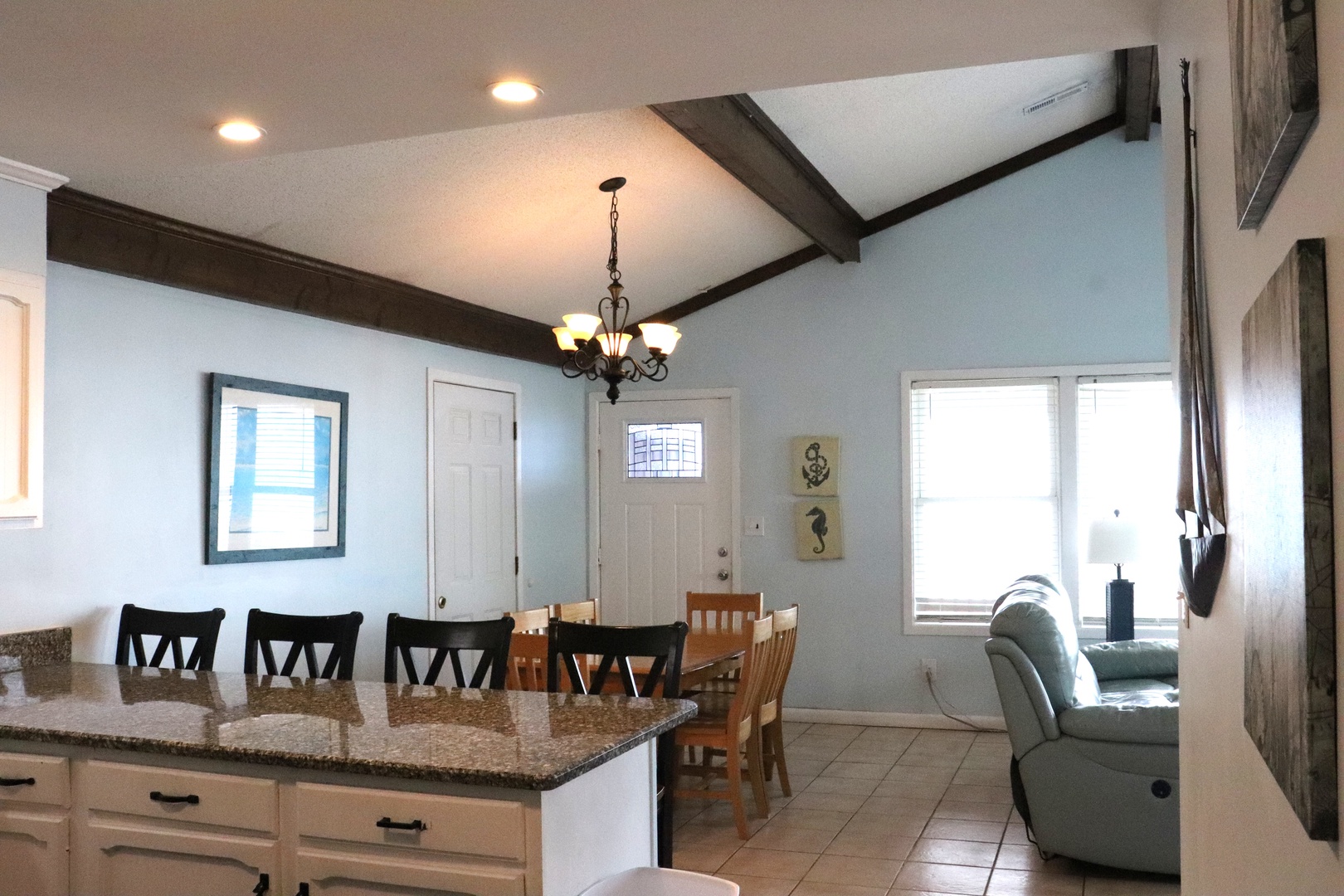 Step into your spacious open-concept living area where rustic beams and coastal decor create a welcoming retreat. The kitchen island invites you to gather, while natural light fills your airy home away from home.