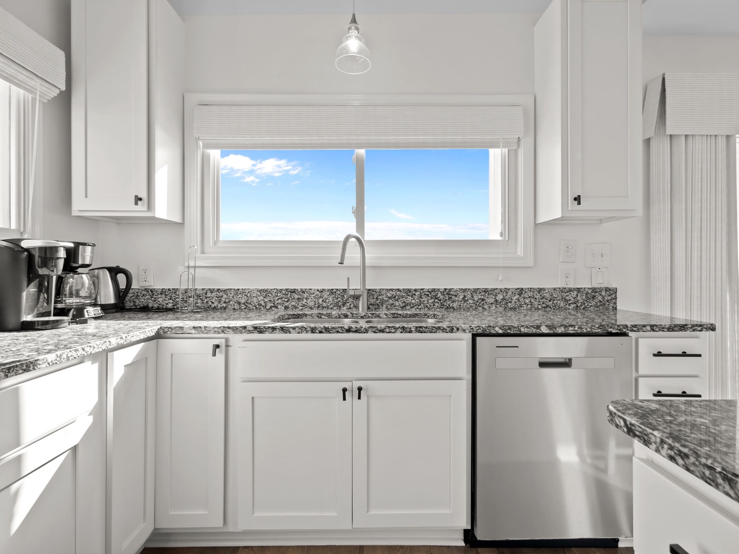 Your bright kitchen features granite countertops, stainless steel appliances, and a window that frames beautiful blue skies while you cook.