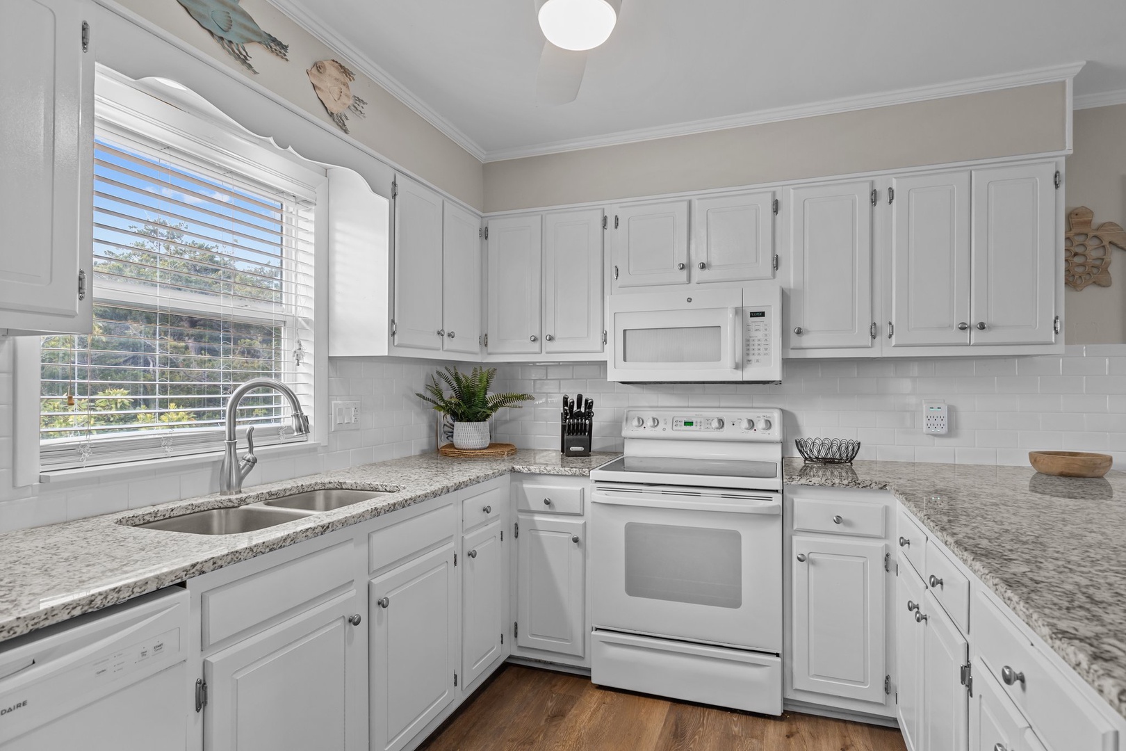 Your fully-equipped kitchen awaits with granite counters, white cabinets, and garden views for memorable meal prep.
