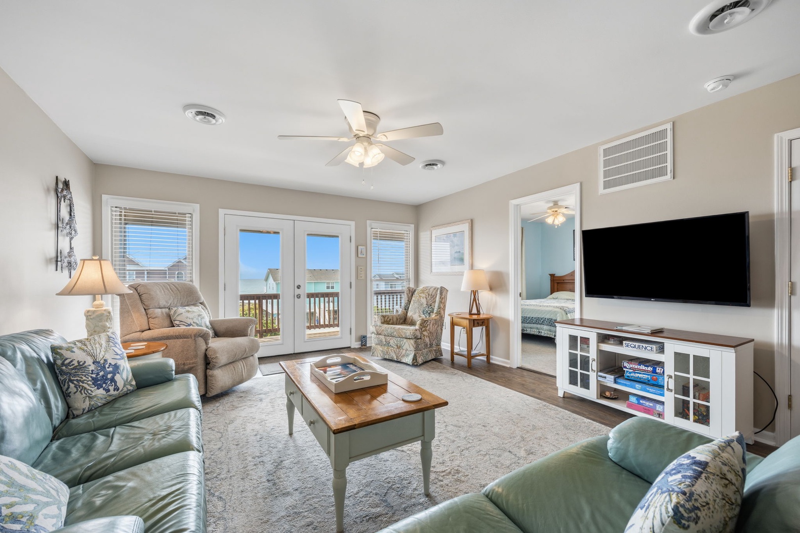 Settle into this bright living room where coastal breezes flow through French doors and your favorite shows await on the large flat-screen TV.