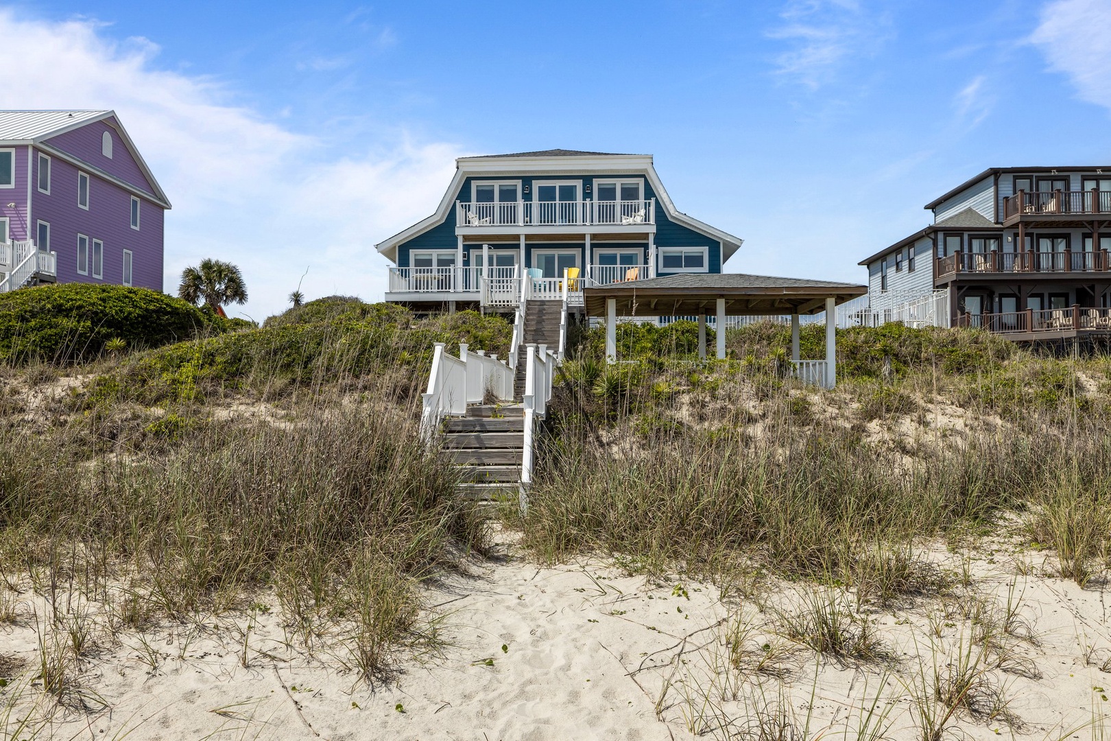 Oceanfront beach house with direct access to pristine sandy shores and natural dune vegetation.