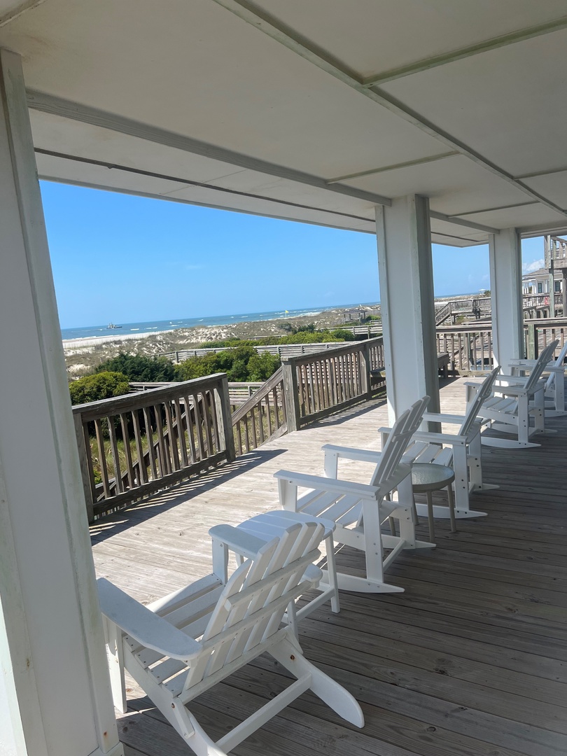 Relax in white rocking chairs on your covered porch, watching waves roll in across pristine coastline stretching endlessly before you.