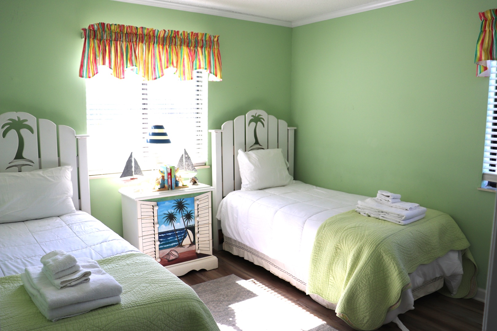 Drift off to sleep in this charming twin bedroom where tropical palm headboards and cheerful green walls create your perfect beach-themed retreat.
