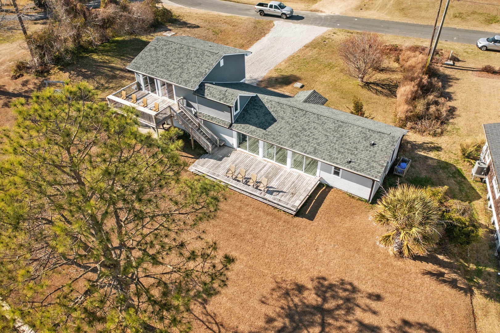 Contemporary beach house with expansive deck and coastal landscaping in a quiet residential setting.