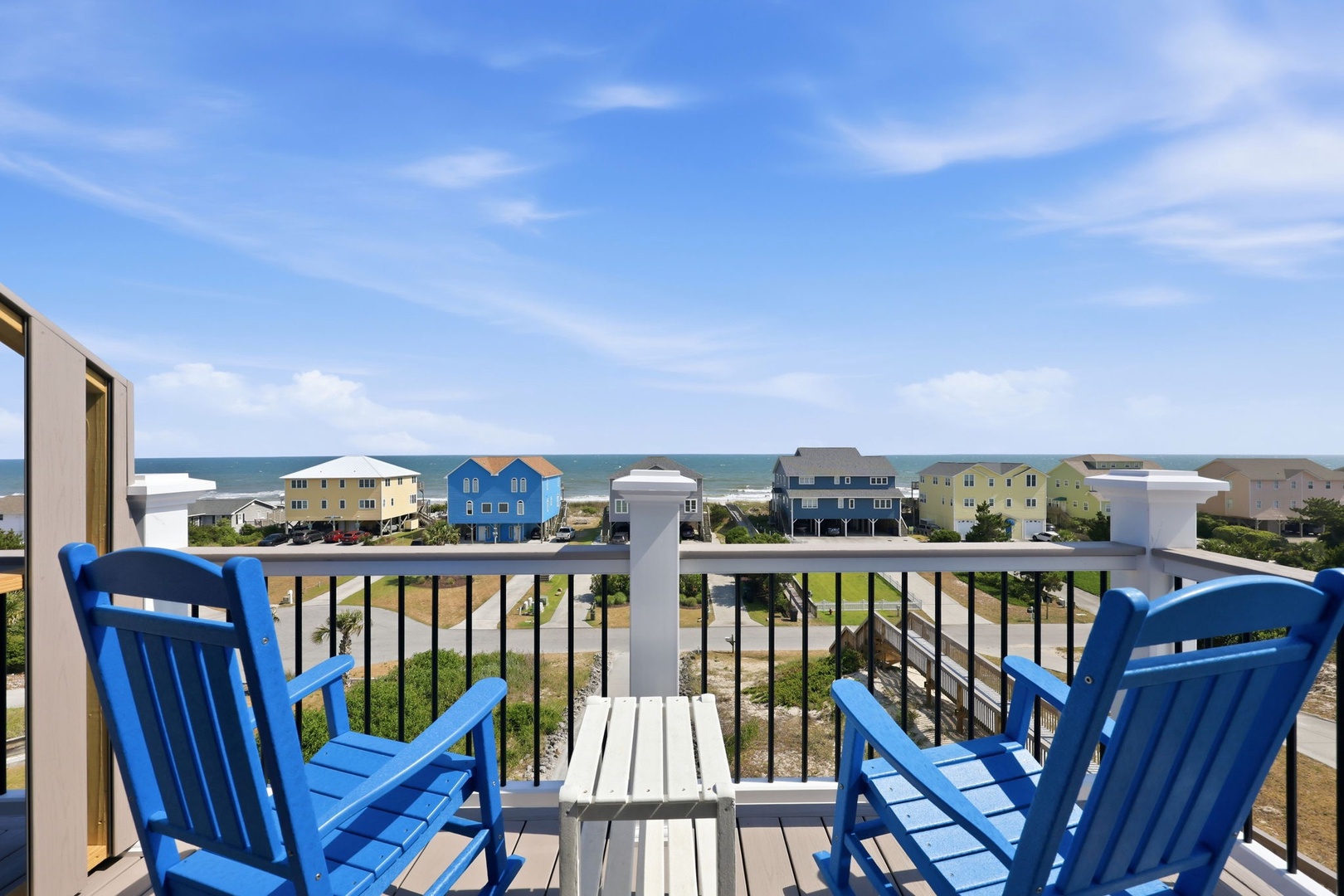 This balcony offers a sweeping view of coastal homes and the Atlantic Ocean beyond. Located within a quiet beachside neighborhood, the property provides a tranquil seaside setting.