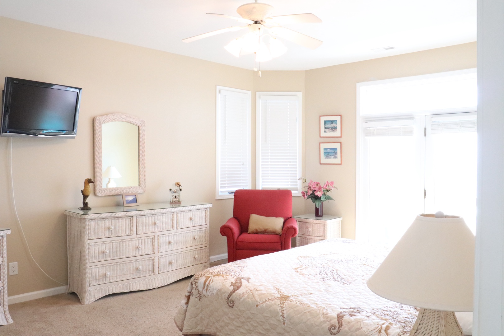 Sink into the soft red chair and catch your favorite shows on the wall-mounted TV in this bright, peaceful bedroom retreat.