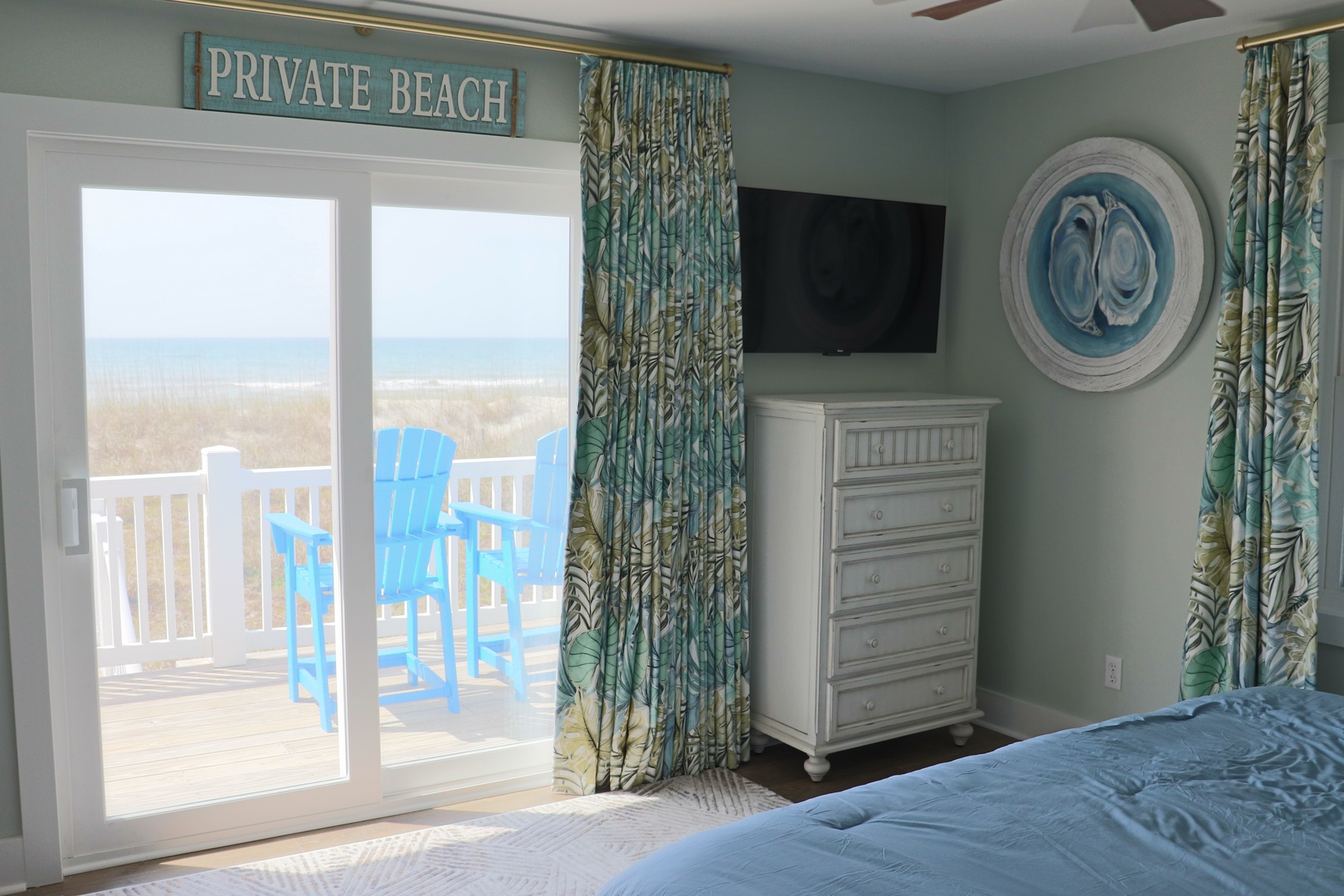 Wake up to endless ocean views from your cozy bedroom, where tropical curtains frame the perfect beach scene outside your door.