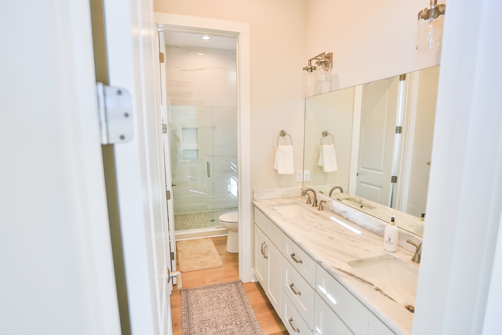 Step into your spa-like bathroom retreat with marble counters, dual vanity, and glass-enclosed shower for ultimate relaxation.