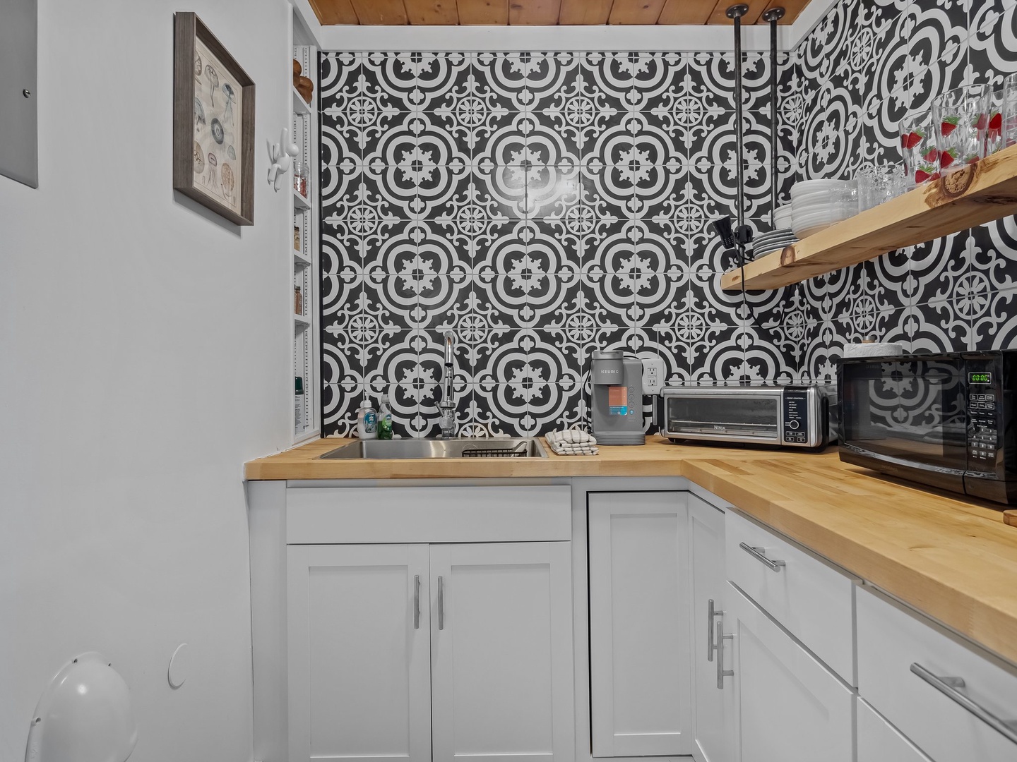Your stylish kitchenette features striking patterned tiles, warm wood counters, and modern appliances for convenient meal prep.