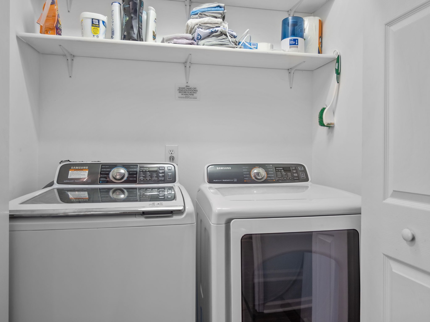 Your private laundry room features modern Samsung washer and dryer with convenient storage shelving above for all your vacation essentials.