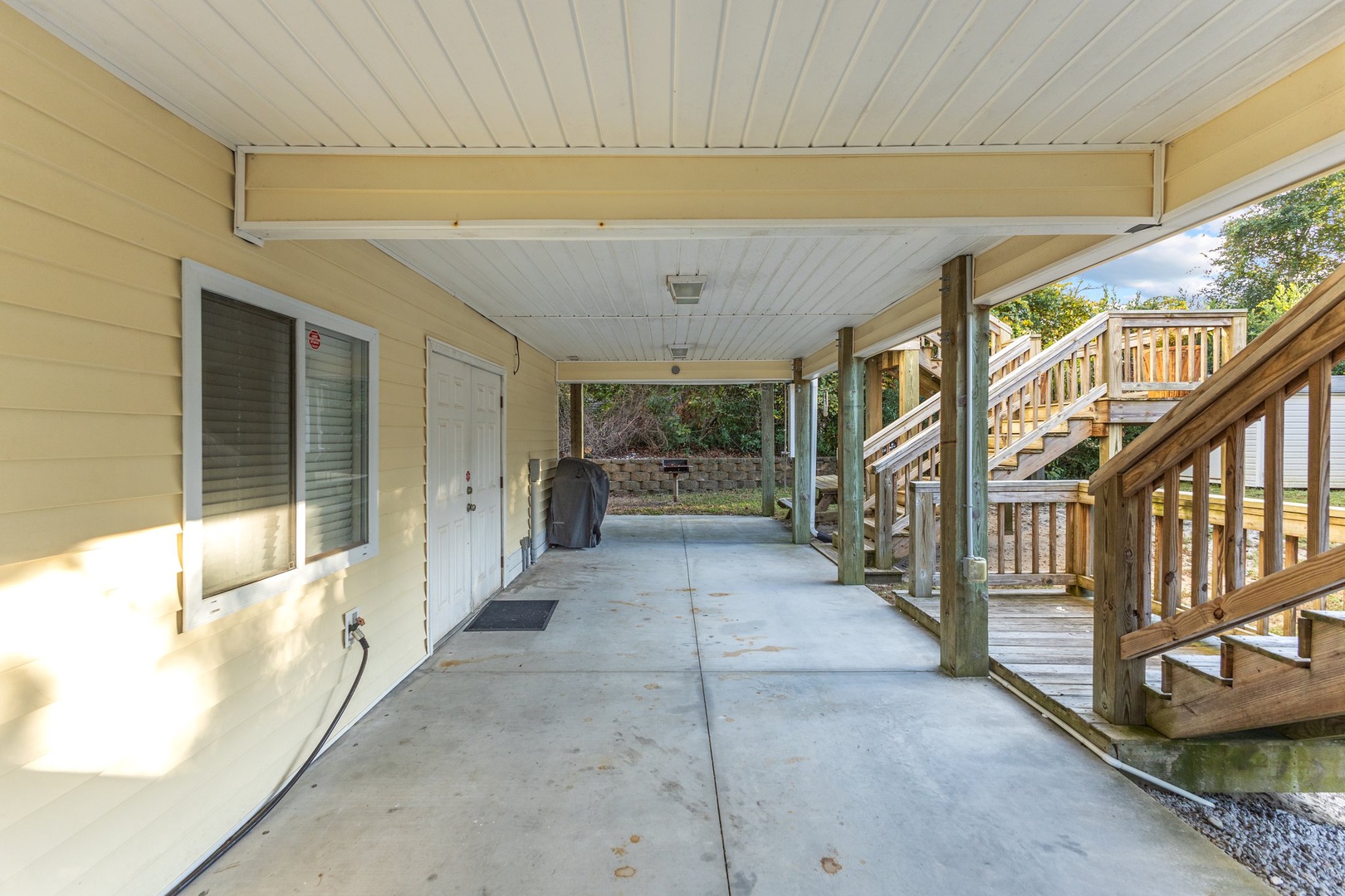 Covered parking area with convenient ground-level access and nearby staircase to upper levels.