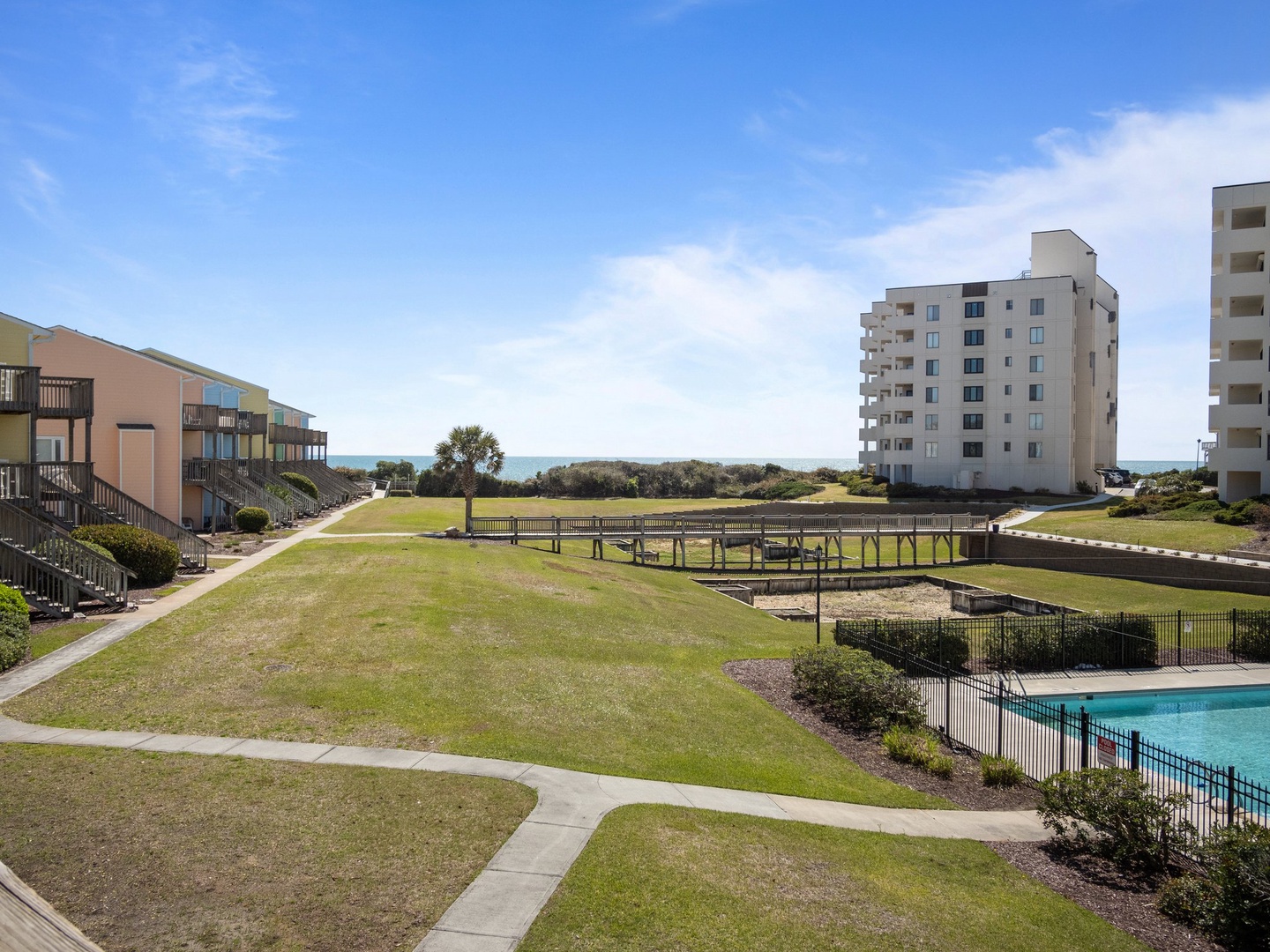 Oceanfront resort complex features landscaped grounds, multiple buildings, and pool facilities with direct beach access.