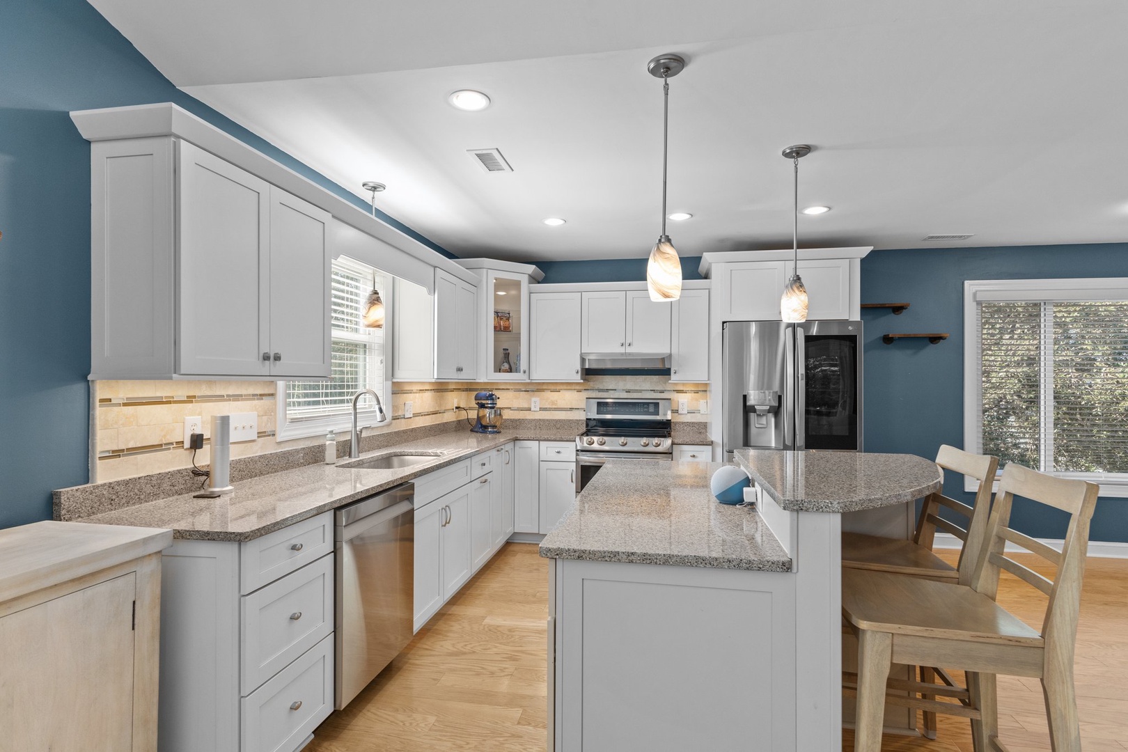 Your spacious kitchen features crisp white cabinets, granite countertops, and modern stainless appliances, perfect for preparing meals during your stay.