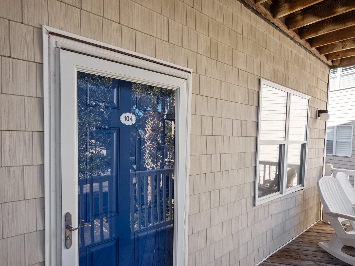 Your coastal retreat awaits behind this charming blue door, where natural shingles and warm wood beams create the perfect beach house welcome.