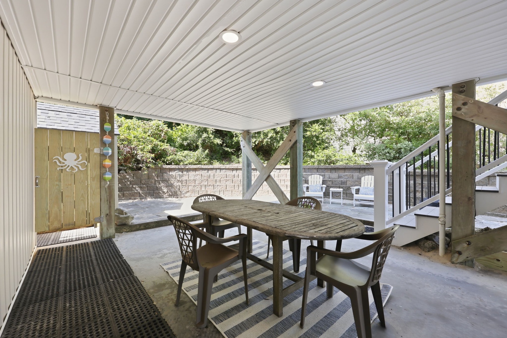 Your covered patio invites you to relax at the spacious dining table, with fresh air and garden views surrounding you—perfect for morning coffee or evening meals.