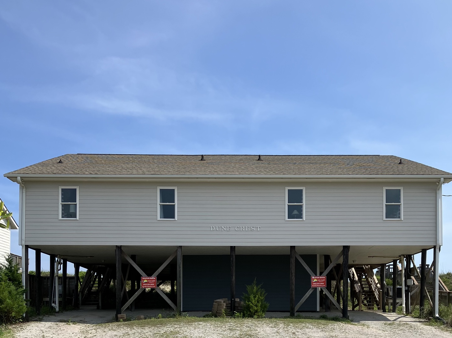 Dune Crest vacation home sits elevated on stilts, offering coastal charm with convenient ground-level parking and storage beneath.