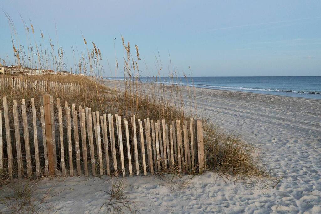 Pristine beachfront location with direct access to wide sandy shores and gentle ocean waves.