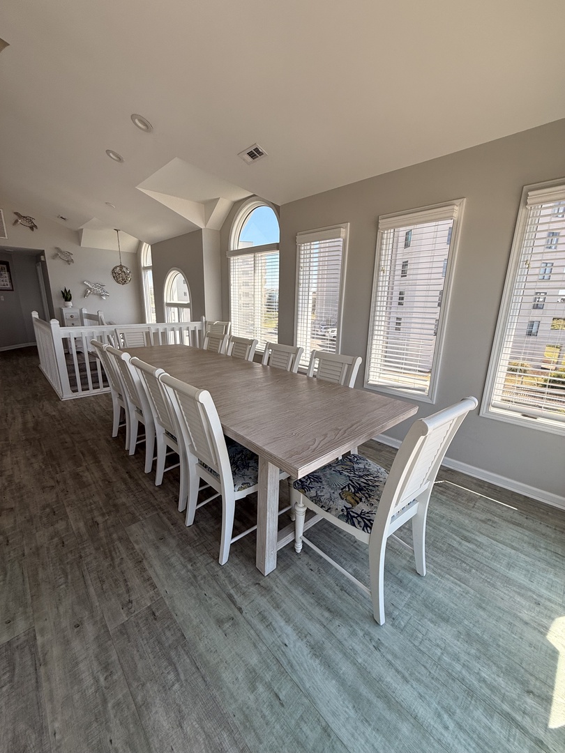 Step into your coastal-inspired dining space with elegant white chairs and a tasteful nautical theme, flooded with natural light from skylights above.