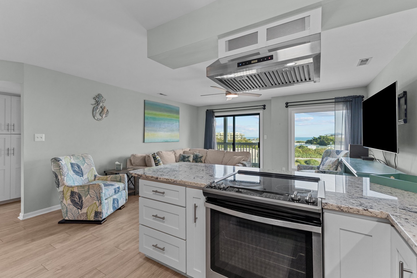 Your open-concept kitchen flows seamlessly into the living area, where you can cook while enjoying water views through oversized windows.