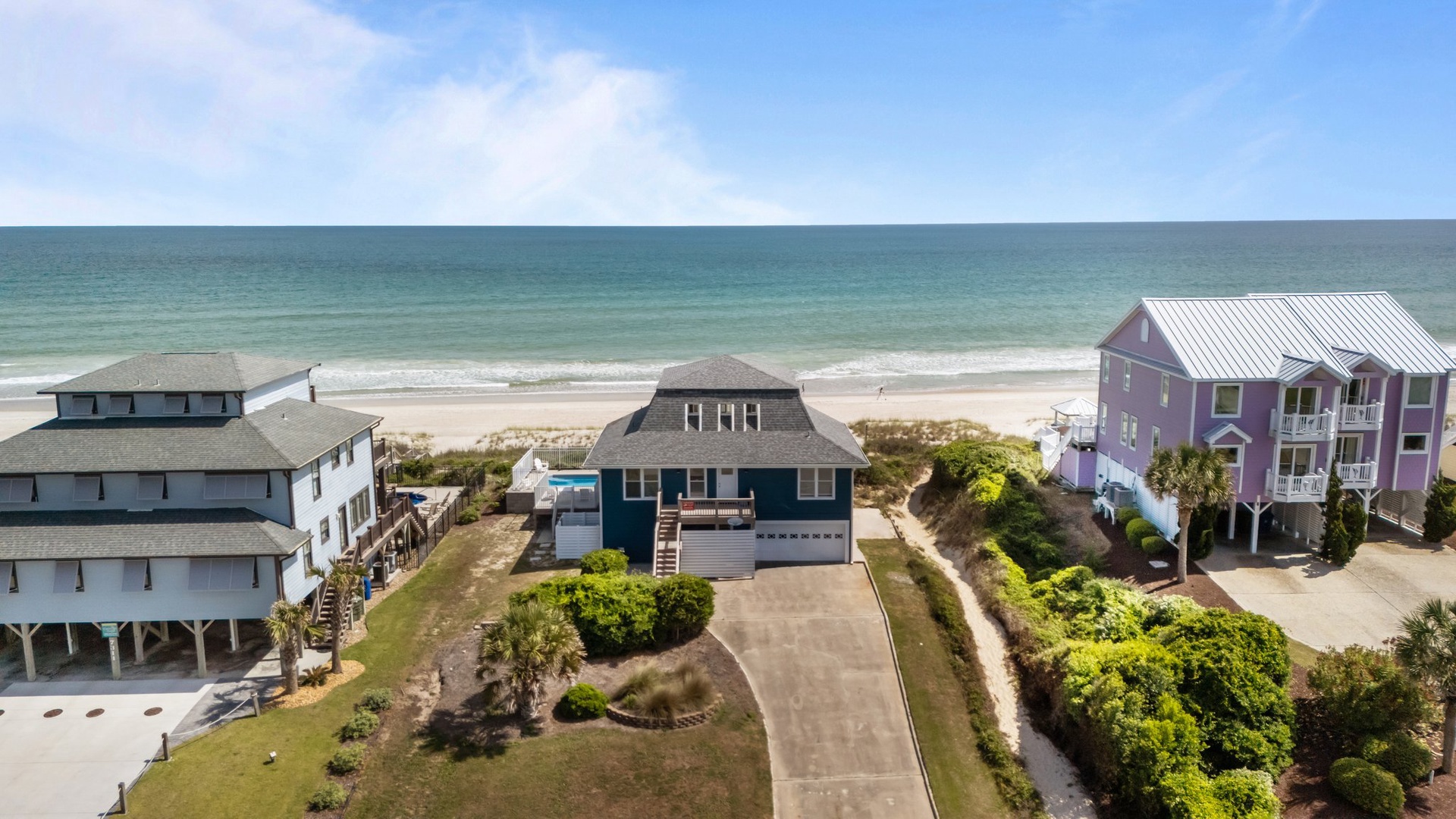 Beachfront vacation homes line the pristine coastline, offering direct access to sandy shores and ocean views.