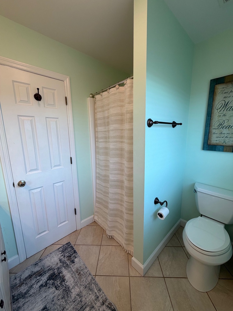 Step into your private bathroom retreat with calming mint walls, elegant tiled floors, and thoughtful touches that make freshening up a pleasure.