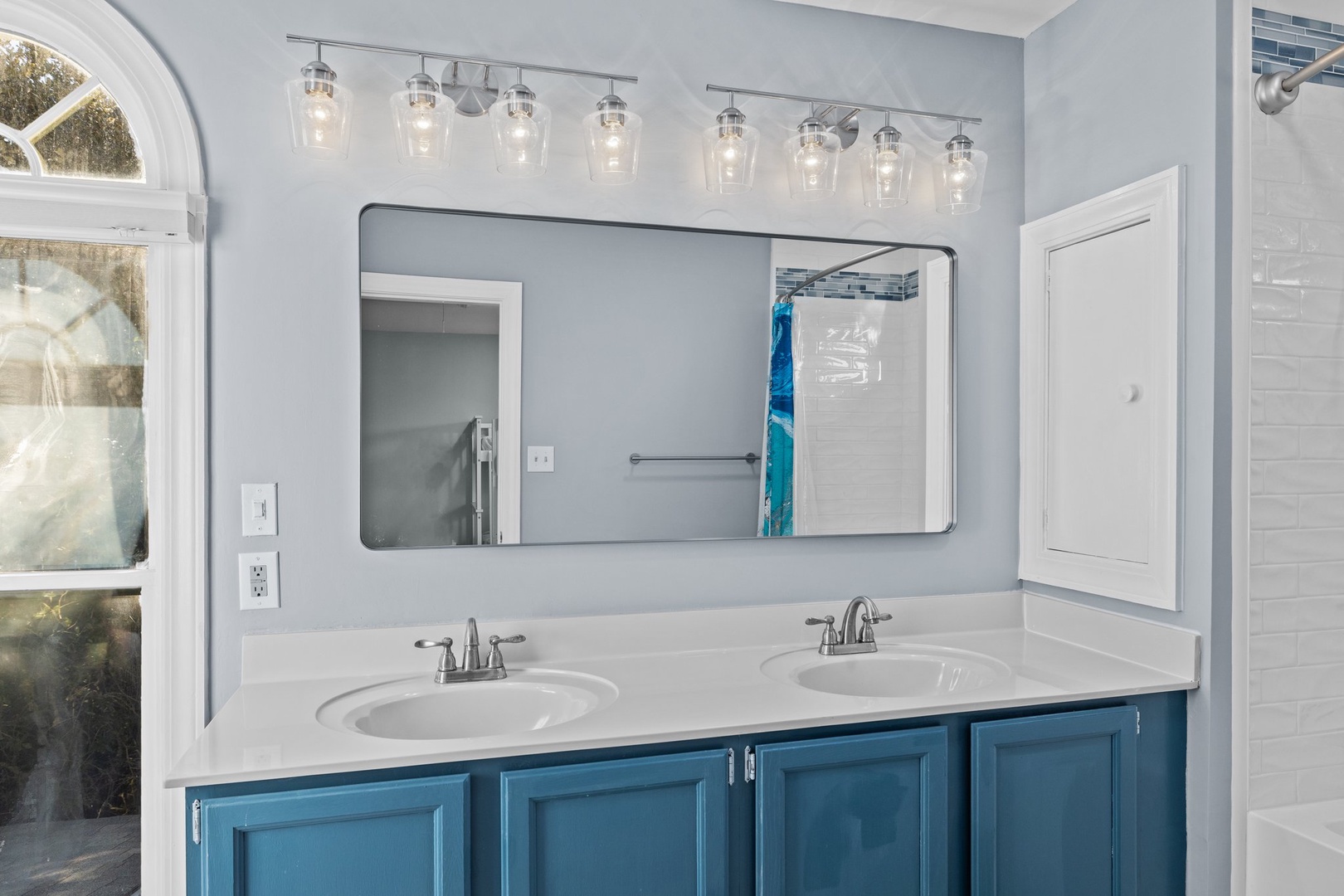 Step into your elegant bathroom featuring dual vanities with polished marble countertops and sparkling pendant lighting for your morning routine.