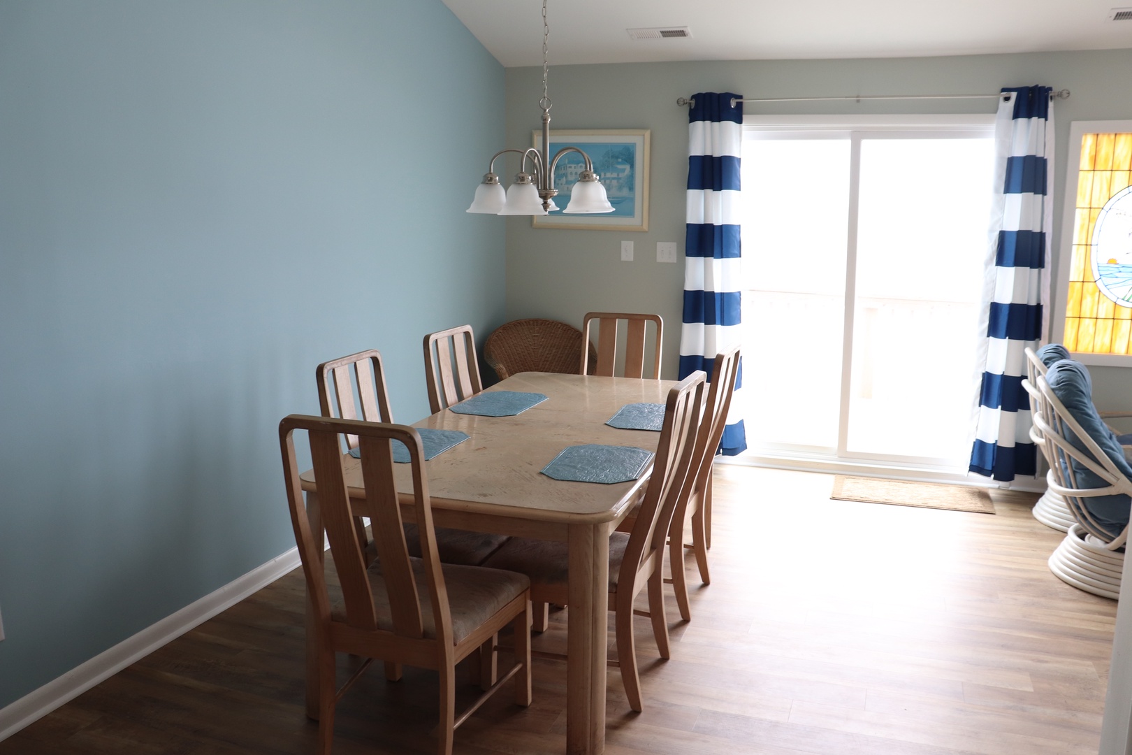 Gather around your bright dining table for memorable meals, with cheerful nautical touches and sunshine streaming through glass doors.