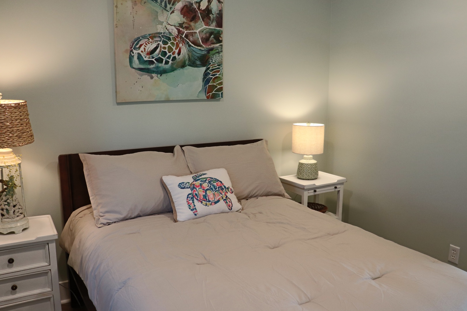 Drift off to peaceful dreams in your cozy bedroom with soft linens and charming sea turtle artwork creating a tranquil coastal retreat.