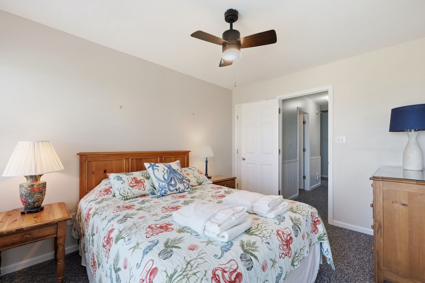 Unwind in your serene bedroom with charming coastal bedding and warm wood furnishings, complete with an en-suite bathroom for your comfort.