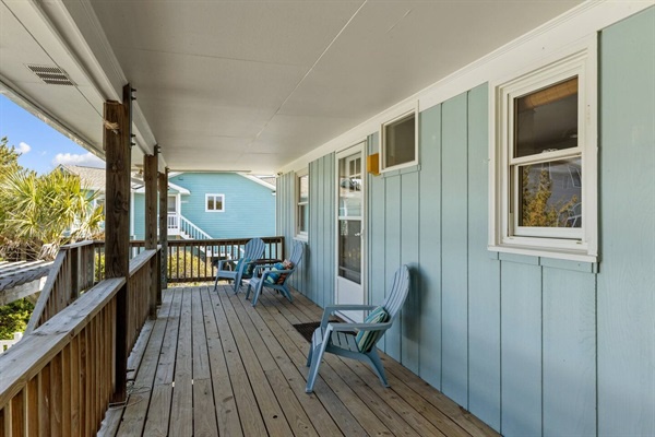 Relax on your covered porch with comfortable seating, watching the coastal breeze flow through this peaceful retreat.