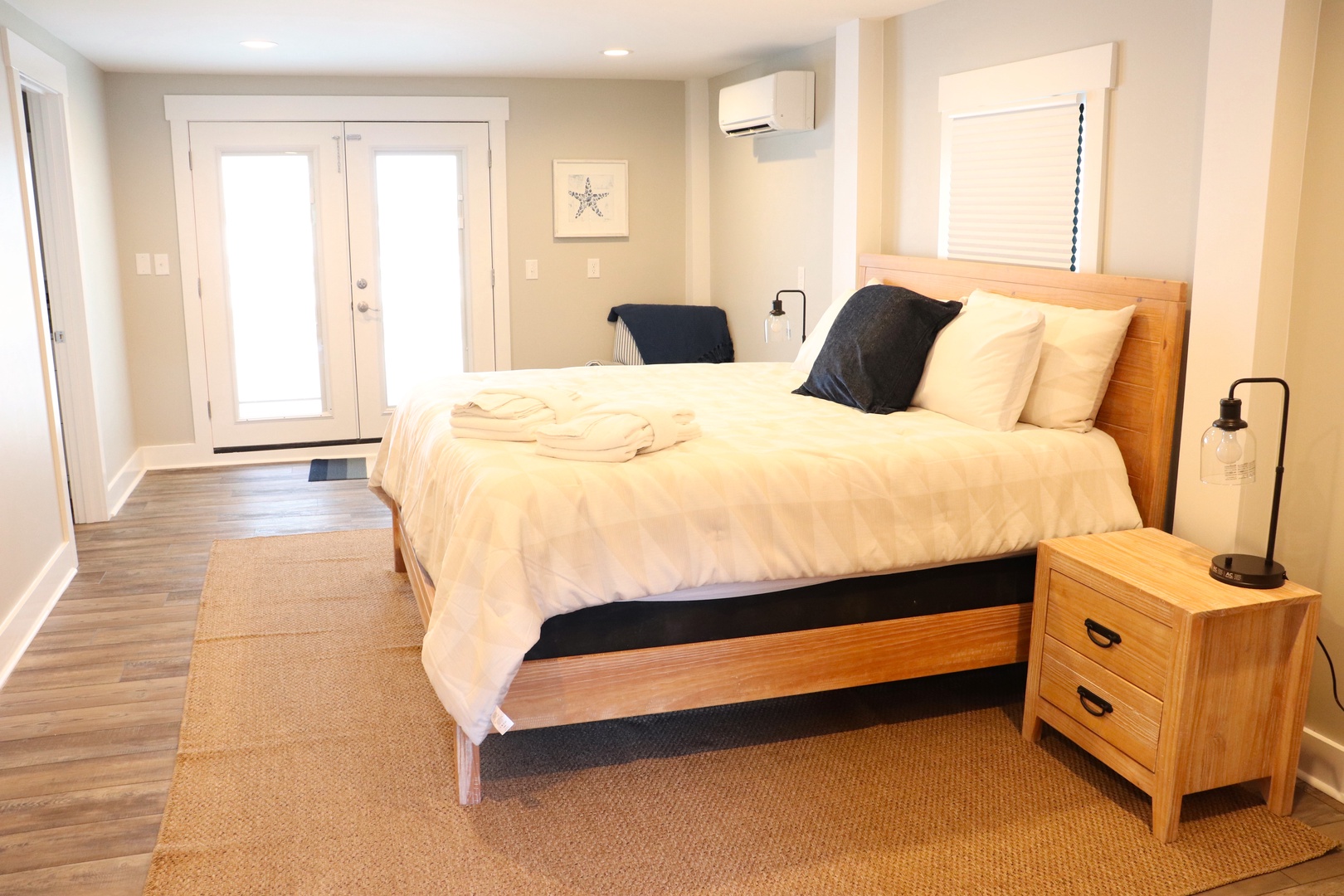 Rest easy in your serene bedroom featuring a comfortable queen bed with crisp linens and warm wood accents that create the perfect coastal retreat.