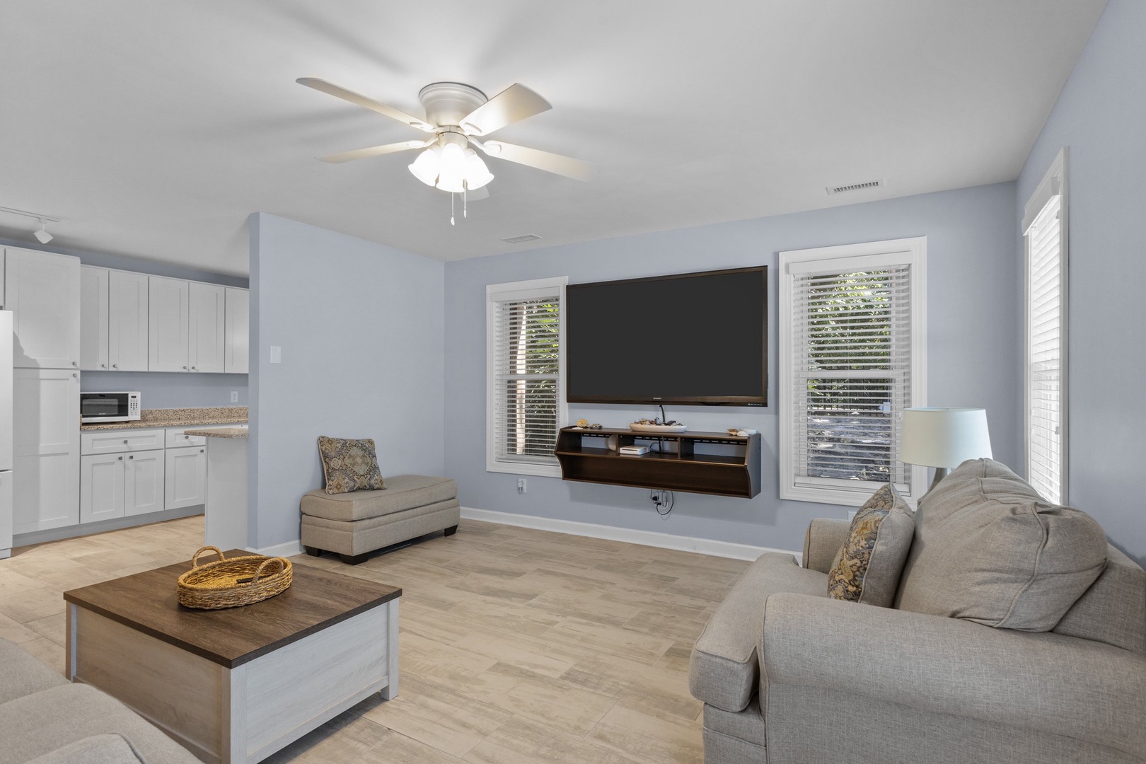 Unwind in your spacious living room with plush seating, modern entertainment center, and calming blue walls that create the perfect atmosphere for relaxation.