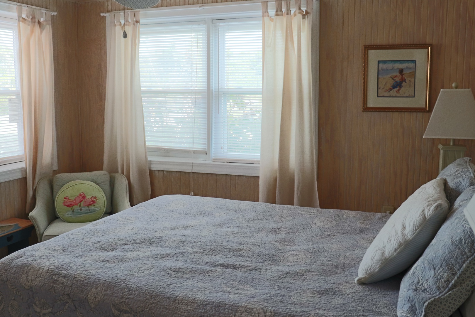 Sink into this cozy bedroom's soft bedding and wake to gentle light filtering through cottage-style windows.