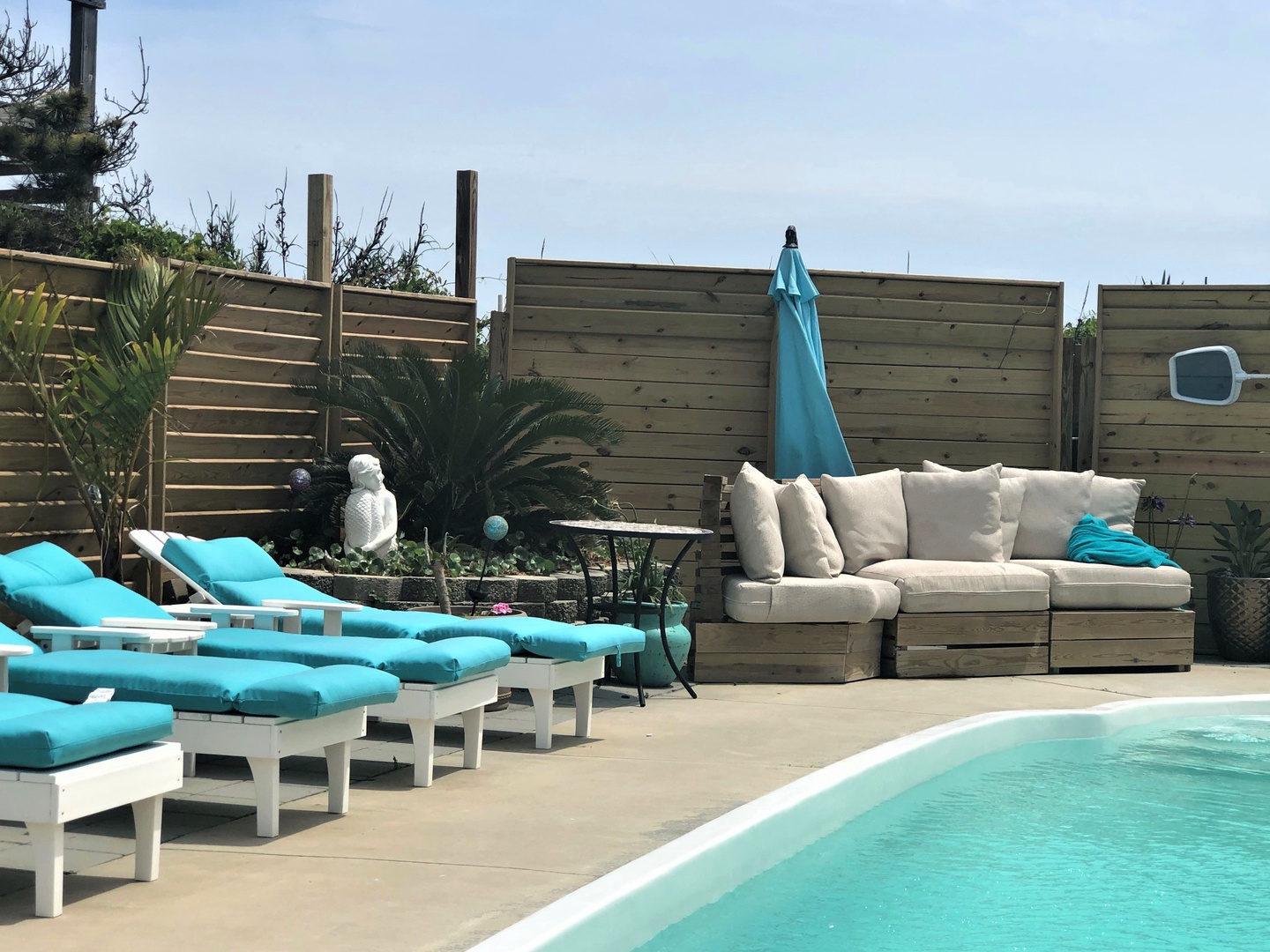 Soak up the sun on your private turquoise loungers beside the sparkling pool, then unwind on plush sectional seating in your secluded garden oasis.
